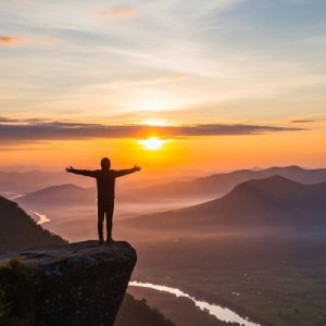 Hombre con los brazos extendidos en una montaña